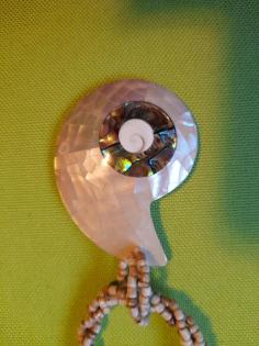Helle Kette mit weißen Perlmuttanhänger in Schneckenform