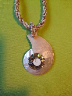 Helle Kette mit weißen Perlmuttanhänger in Schneckenform